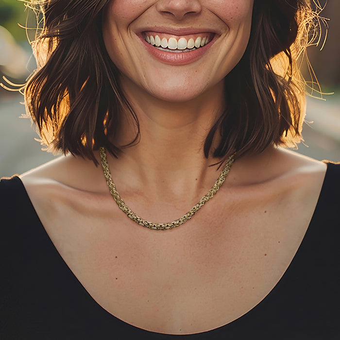 Gold-tone Byzantine chain necklace with curb links, worn at the collarbone