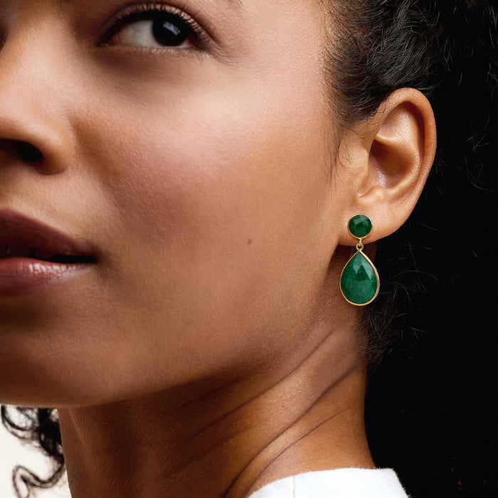 Emerald-green teardrop drop earrings on ear, gold setting