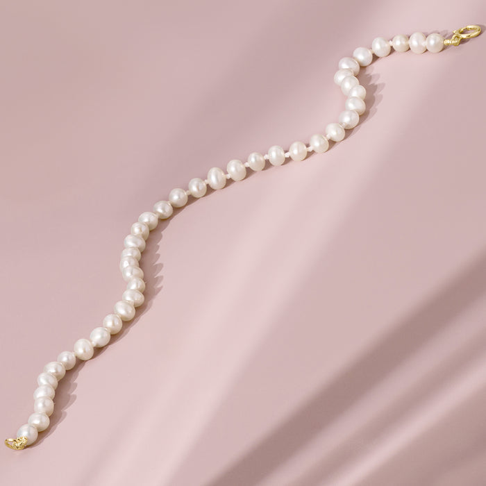 White pearl bracelet with gold clasp, single row design