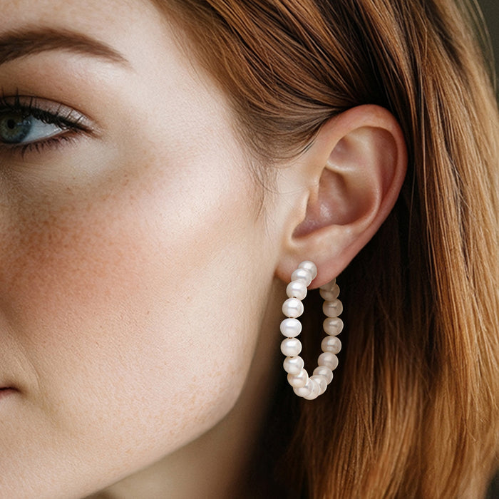 Cultured pearl hoop earrings with round pearls, 14kt yellow gold hoops on model