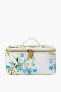 The Neely & Chloe x Inslee small rectangular white vanity case features blue floral prints, a top handle, and a gold zipper with dual pulls—perfect for gifting this holiday season.