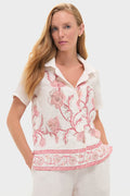 Woman wearing Hibiscus Bloom Pink Gabriella Shirt, a classic, effortless linen piece with pink floral embroidery and a relaxed camp-collar, embodying fun, high-end style.