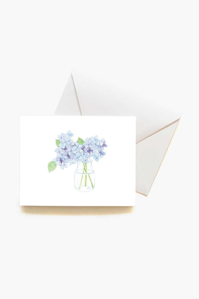 This Sara Fitz greeting card features a watercolor blue hydrangea in a glass jar on a white envelope—perfect for gifting with the Hydrangea Boxed Notes Set or as lovely stationery for any hostess gift.