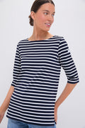 Woman in a Saint James navy and white boat neck top with three-quarter sleeves, featuring classic nautical stripes.