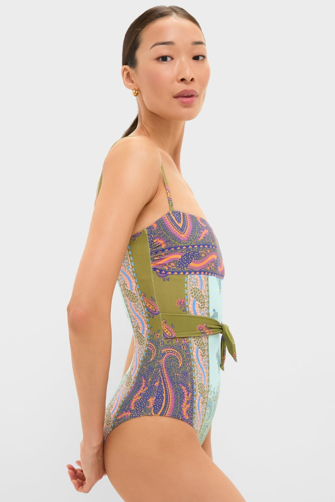 Model in profile wears the Pastel Patchwork Lucent One Piece swimsuit, showcasing its classic, bohemian design with an effortless fit and fun, high-end details like a self-tie belt.