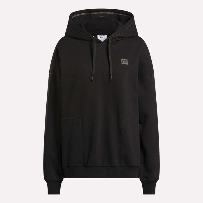 The Women's Relaxed Fleece Hoodie by Reebok is shown against a plain white background. This black hoodie features a front pocket, adjustable drawstrings, and a small square Reebok logo on the left chest.